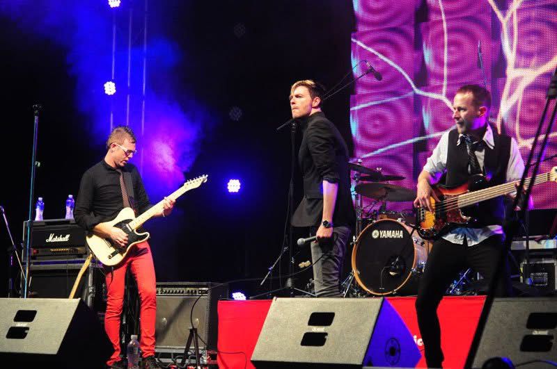 Ryno with bandmates performing live on a concert stage